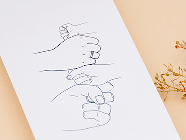 een geboortekaartje met een lijnillustratie pentekening van de handen als vuisten op elkaar